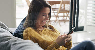 Buy stock photo Happy woman, relax and scroll in home with phone, social media post and dating site notification. Person, smile and browsing on sofa with tech, text message and mobile app for online communication.