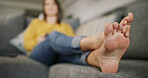 Feet, woman and relax on couch at house for peace, calm morning and comfortable in living room. Toes, female person and rest on sofa for weekend break, unwind and chilling in lounge for stress relief