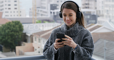 Buy stock photo Headphones, phone and woman on balcony with music for texting, social media or contact on mobile app. Audio tech, cellphone and female person listening to playlist and chatting online outdoor of home