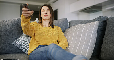 Buy stock photo Woman, watching tv and relax on sofa with remote in home, smile and streaming for movie in living room. Person, happy and search for film choice, subscription or low angle with television at house