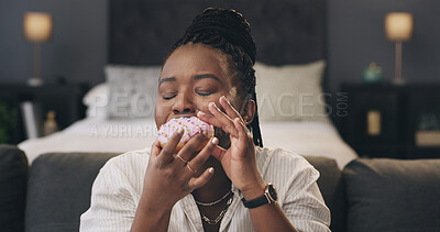 Buy stock photo Black woman, relax and eating donut on couch in home, sweet snack and junk food on break in bedroom. African person, pastry or dessert on sofa for sugar craving, cake and cheat meal at apartment