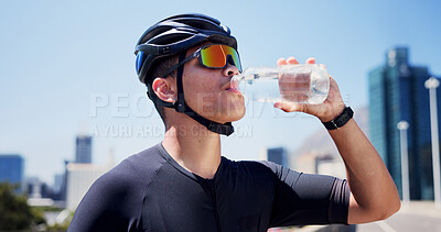 Buy stock photo Man, cyclist and drinking water in city, fitness and helmet on bridge, break and hydration in street. Person, bottle and rest with training, outdoor or liquid for electrolytes with sunglasses in town