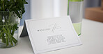 New home, note and welcome with card on table in apartment for congratulations or message. Investment, property and real estate with greeting letter in living room on moving day for relocation