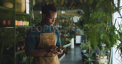 Buy stock photo Black man, tablet and reading in nursery with checklist, inventory management or supplier order. Botanist, sustainable business and tech in store for plant storage, website update or quality control