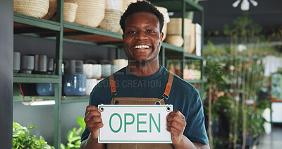Buy stock photo Black man, open sign and portrait in nursery for sustainable business, botany and eco friendly startup. Botanist, happy and board in plant store for operating hours, service announcement and pride
