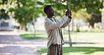 Black man, travel and outdoor with phone for photography, blog update and sightseeing on trip. Person, tourist and mobile in park for picture, sharing location and social media engagement in Nigeria