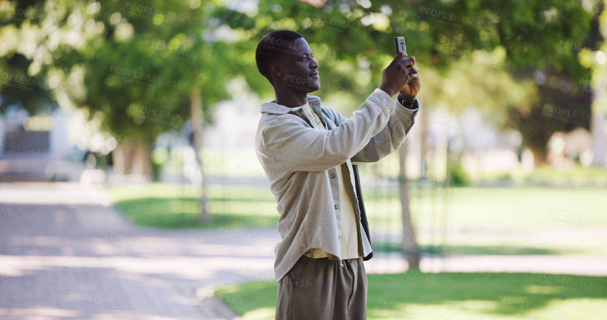 Buy stock photo Black man, travel and outdoor with phone for photography, blog update and sightseeing on trip. Person, tourist and mobile in park for picture, sharing location and social media engagement in Nigeria