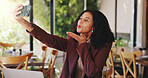 Woman, selfie and blow kiss in restaurant for social media, blog update and content creation. Customer, gesture and photography in cafe for networking, share post online and follower engagement