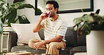 Man, relax and herbal tea with glass on sofa for cool beverage, thirst or refreshment in home. Male person, chilling and rest with drink or comfort for healing remedy, vitamins or nutrition in house