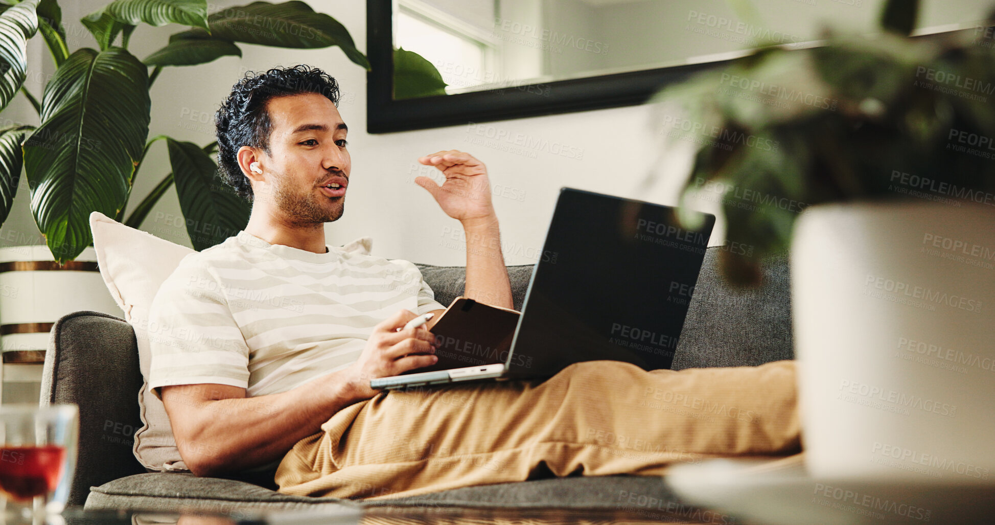 Buy stock photo Man, laptop and video call on sofa for remote work from home, earphones and discussion in living room. Person, virtual assistant and computer for online meeting, notebook and feedback at apartment