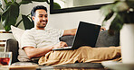 Man, relax and smile with laptop in home for movie, streaming film or listen to video. Person, living room and digital tech for social media, online podcast and search for internet entertainment
