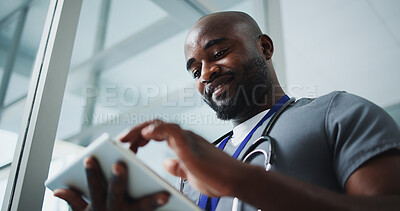 Buy stock photo Black man, doctor and smile with tablet in hospital for research, medical report and test results. Below, male person and digital for healthcare information, treatment planning and surgery schedule