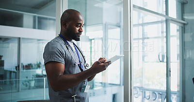 Buy stock photo Black man, surgeon and reading with tablet in hospital for research, medical report and test results. Doctor, male person and digital for healthcare schedule, treatment planning and surgery feedback