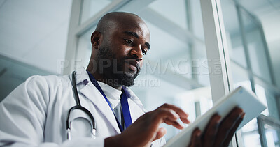 Buy stock photo Below, black man and doctor with tablet in hospital for research, medical report and test results. Male person, reading and digital for healthcare information, treatment planning and surgery schedule