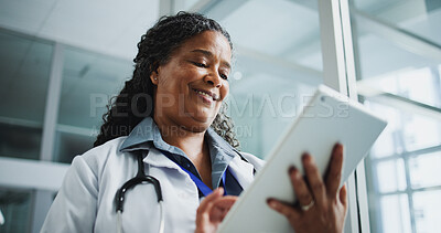 Buy stock photo Woman, doctor and reading with tablet in hospital for research, medical report and test results. Mature, African person and tech for healthcare information, treatment planning and feedback from below