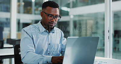 Buy stock photo Reading, laptop and business black man in office for financial review, investment research and website. Corporate, glasses and person on computer for finance report, budget planning and expenses