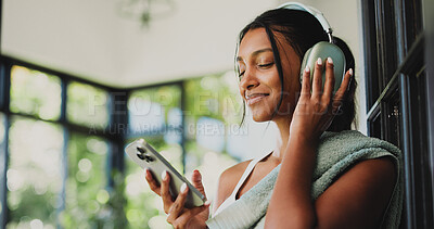 Buy stock photo Fitness, headphones and woman with smartphone, music and subscription for entertainment or playlist. Happy, Indian person and listening to audio with tech, streaming and mobile app for song in house