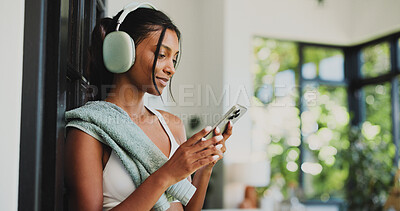 Buy stock photo Fitness, headphones and woman with smartphone, texting or communication with contact on social media. Happy, athlete and Indian person with mobile for chat, space and subscription for music in house