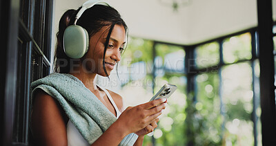 Buy stock photo Fitness, headphones and woman with smartphone, online or communication with contact on social media. Happy, athlete and Indian person with mobile for chat, space and subscription for music in house