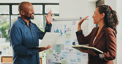 Buy stock photo Business people, notebook and laptop with high five in office for finance agency or project management. Tech, celebration and graphs with man, woman and mentor in workplace for conversation or update