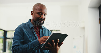 Buy stock photo Web designer, black man or reading with tablet in home, site optimization or check homepage features. Review project, freelance or mature person with domain update, tech or planning of brand identity