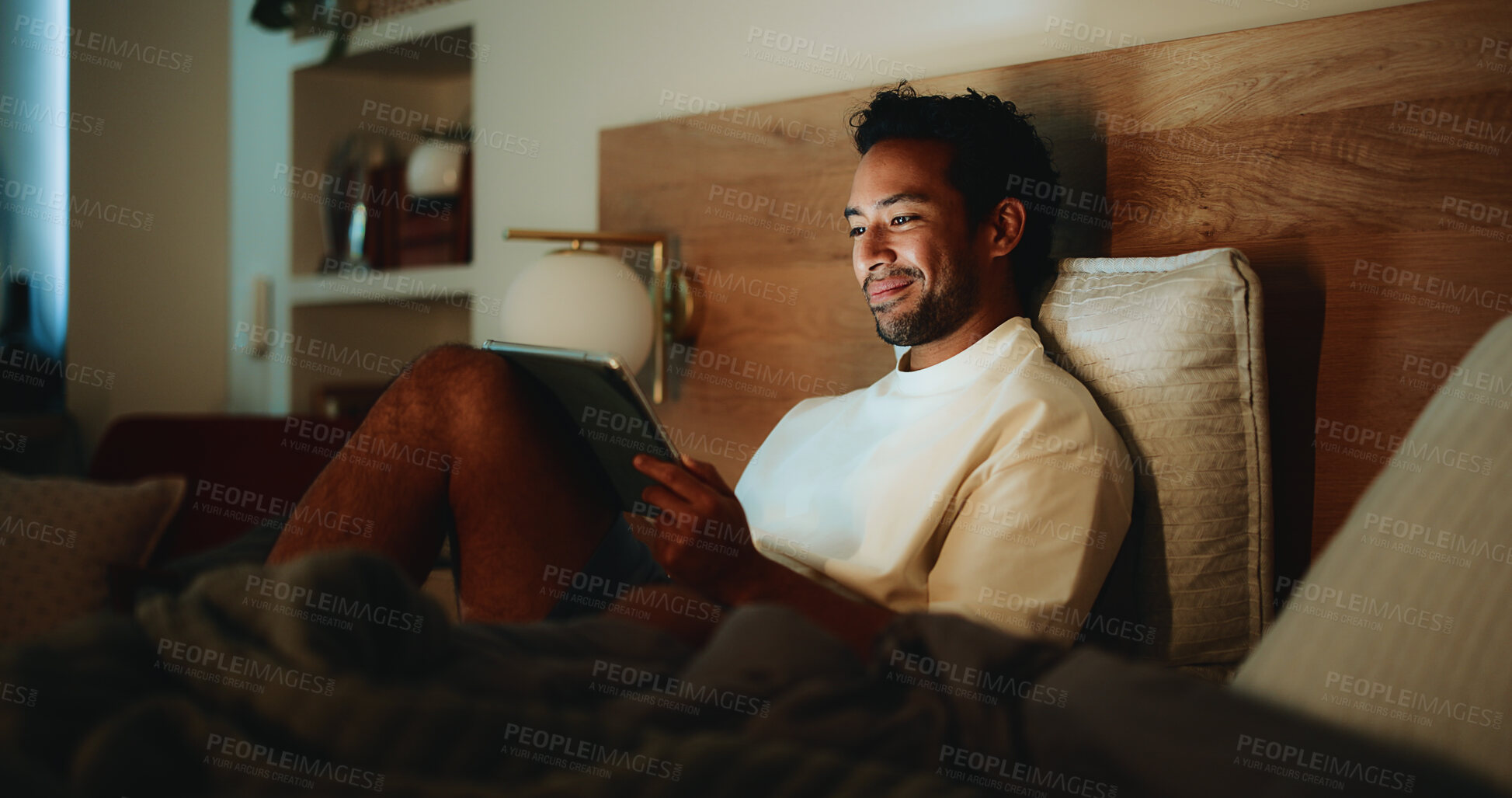 Buy stock photo Tablet, happy and man in bed in home at night for watching movie, series or film for entertainment. Digital technology, app and person streaming show online on website in bedroom in evening at house.
