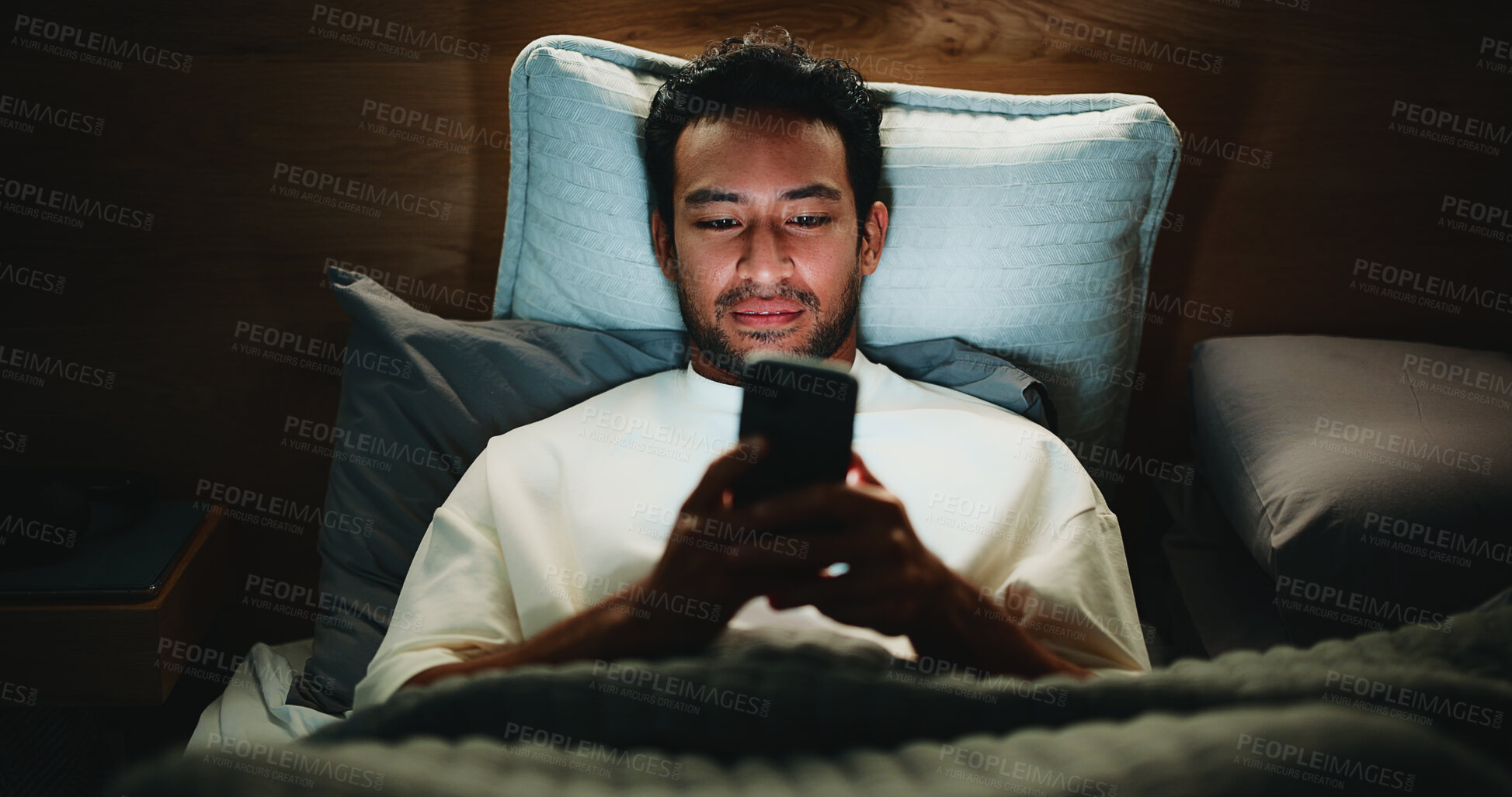 Buy stock photo Night, man and scroll in bed with phone for text message reply, social media and watching viral video. Late, person and browse with tech in apartment for online conversation, internet and mobile app.