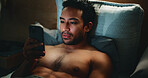 Home, smartphone and man in bedroom, night and relax with blue light exposure. Apartment, mobile user and Asian person with cellphone, evening and social media with internet, scroll or online reading
