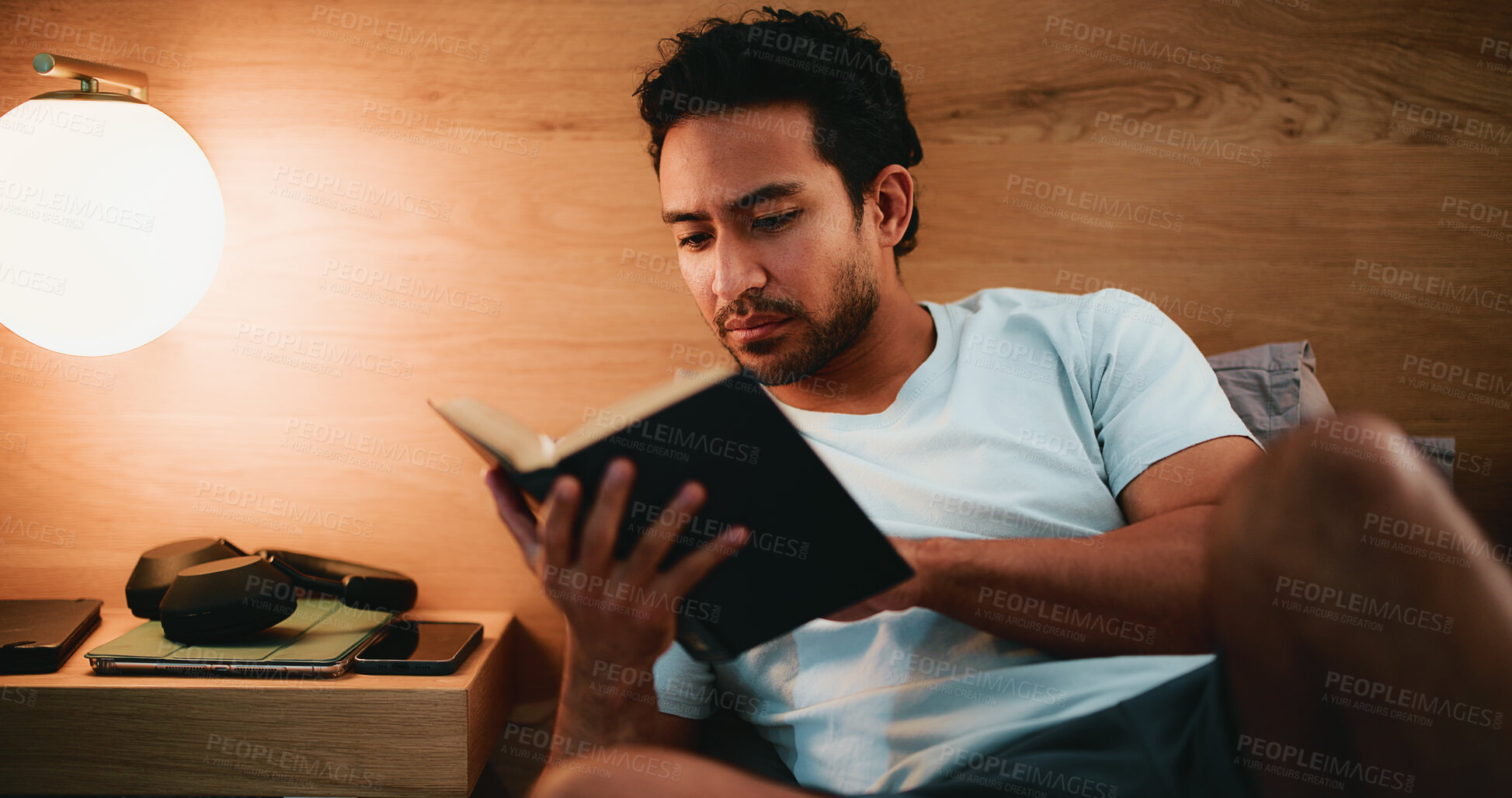 Buy stock photo Reading, book and man in bed at night in home with relax for hobby, knowledge or entertainment. Calm, late and male person in bedroom with fiction story, novel or literature on weekend in apartment.