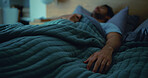 Sleeping, tired and man in bed at night for resting, dreaming and exhausted for nap in home. House, bedroom and person with blanket, bedding and comfortable for wellness, fatigue and peaceful