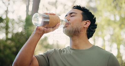 Buy stock photo Man, fitness and drinking with water in forest for hydration, exercise break or rest in nature. Active, male person or runner with mineral liquid for natural sustainability or recovery in woods