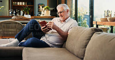 Buy stock photo Reading, book and mature man on sofa with smile, calm and literature hobby on weekend rest. Free time, study and senior person in house with novel, relax and fantasy story on Saturday afternoon.