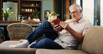 Buy stock photo Reading, book and mature man on sofa with glasses, calm and literature hobby on weekend rest. Free time, study and senior person in house with novel, relax and fantasy story on Saturday afternoon.