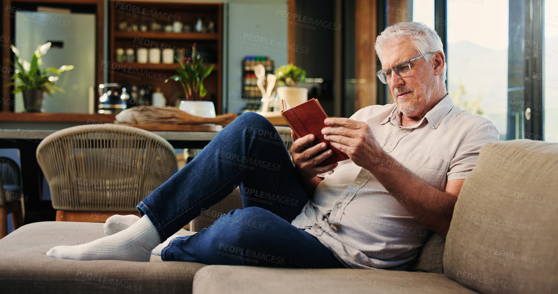 Buy stock photo Reading, book and mature man on sofa with glasses, calm and literature hobby on weekend rest. Free time, study and senior person in house with novel, relax and fantasy story on Saturday afternoon.