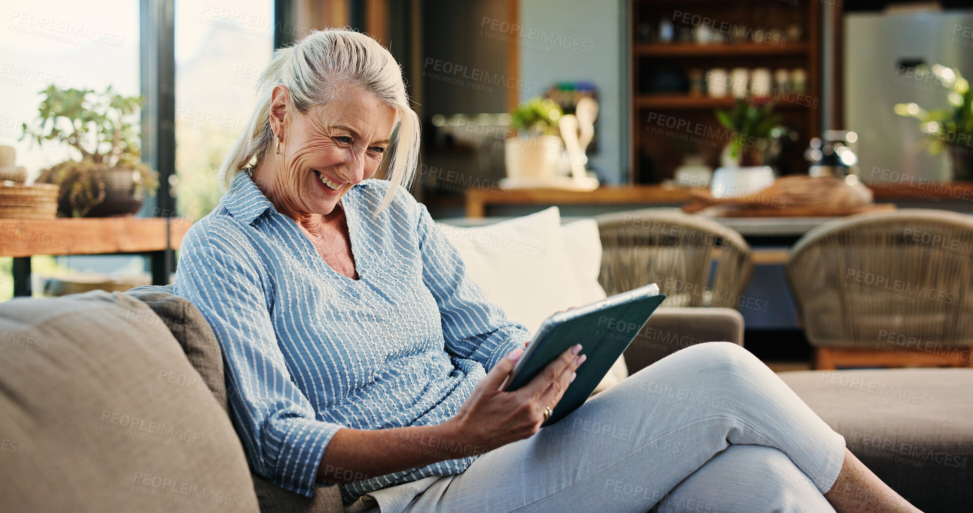 Buy stock photo Laughing, woman and relax with tablet, lounge and watching video on social media or app subscription. Online, entertainment and mature person with tech for funny movie, home and streaming on website