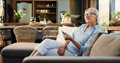 Buy stock photo Senior woman, watching tv and remote on sofa, smile and click for movie choice in retirement at house. Elderly person, happy and relax on couch with television, streaming or film subscription in home