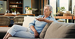 Senior woman, watching tv and remote on couch, search and click for movie choice in retirement at house. Elderly person, television show and relax on sofa with streaming, film or subscription in home