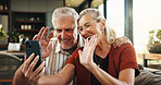 Old couple, waving and phone for video call at house with discussion, friendly chat and bonding. Smile, elderly people and hello with mobile for online conversation, contact and funny joke in lounge