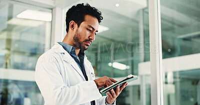 Buy stock photo Man, doctor and reading with tablet in hospital for research, medical report and confirm surgery. Male surgeon, digital and review website for Telehealth, healthcare results and treatment information