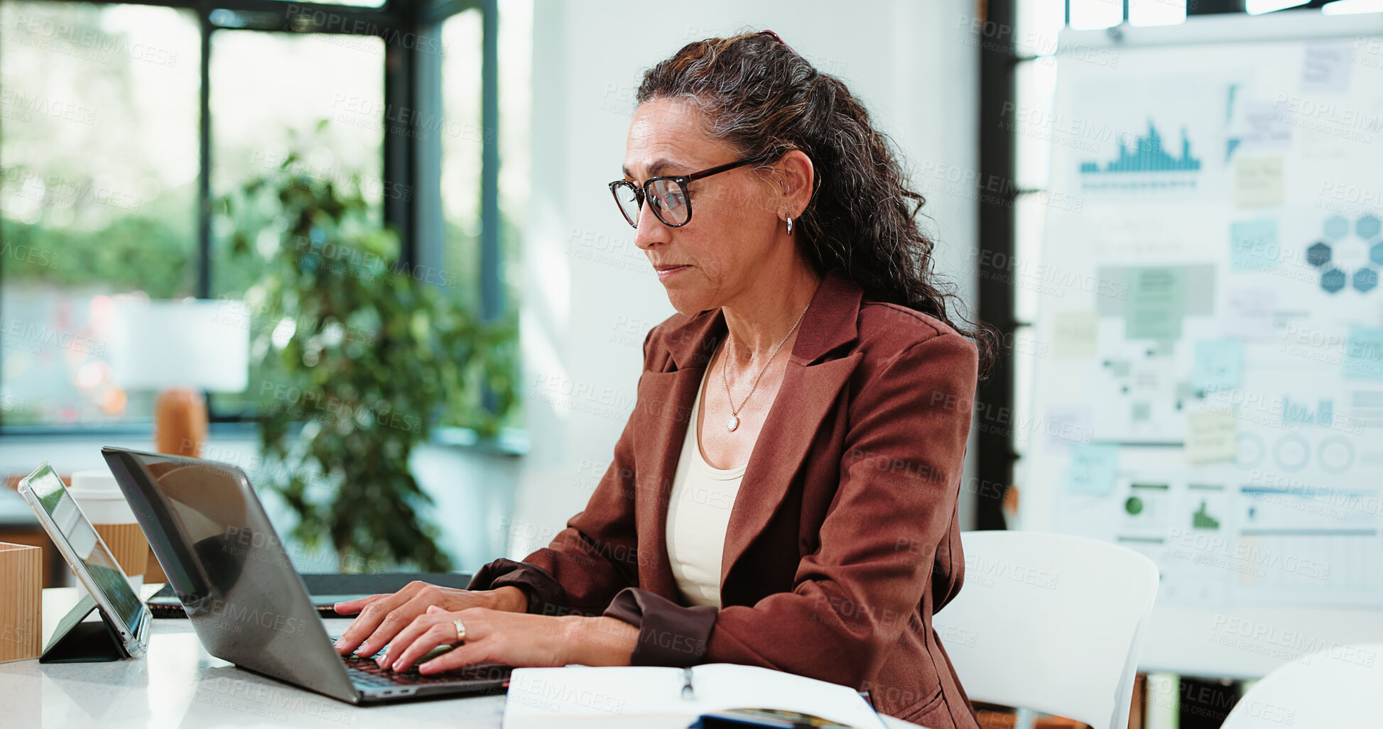 Buy stock photo Laptop, typing and business woman in office for financial review, statistics or budget report. Corporate, planning and mature person on computer with graph, documents or research for finance analysis