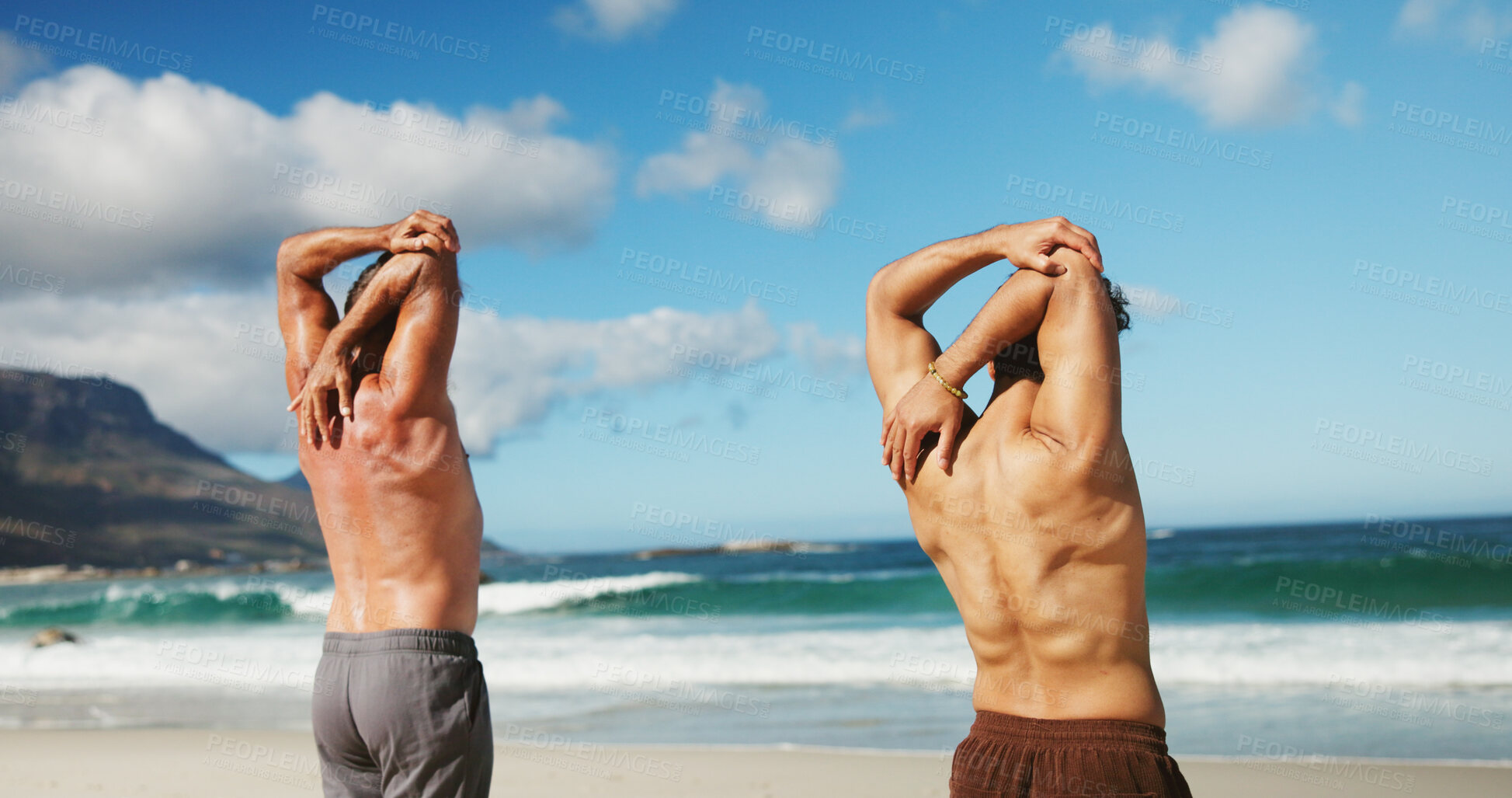 Buy stock photo Instructor, arm stretching and people by beach, fitness training or warm up routine for wellness. Coach, back or men with workout activity for muscle mobility, flexibility challenge or support by sea