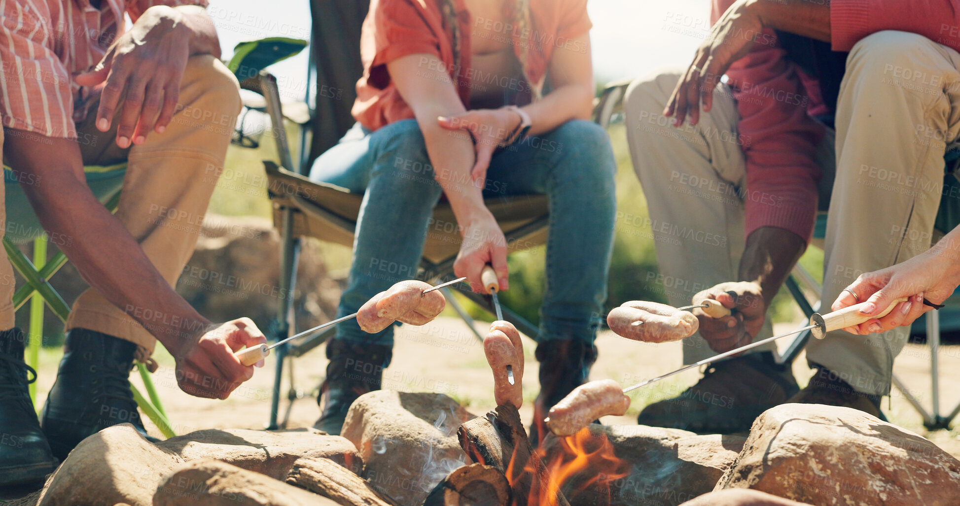 Buy stock photo Hands, campfire and group with cooking meat, outdoor and sausage on vacation, break and bonding in summer. People, friends and flames with food, hungry and relax outdoor in countryside on holiday