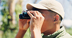 Bird watching, binocular and man in forest, travel and hobby for adventure, explore and nature. Journey, tourism and person in woods, sightseeing and expedition with scope, environment and trekking