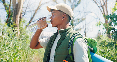 Buy stock photo Man, hiking and drinking water in forest, break and hydration on adventure, bag or tired in summer. Person, bottle and backpack with electrolytes, profile and trekking with nature tourism in woods