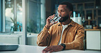 Black man, drinking water and wellness with remote work from home, detox and liquid for self care with gut health. African person, glass and freelance writer with hydration, laptop and break in house