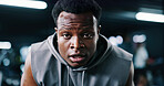 Portrait, tired and black man in gym for fitness break, wellness and recovery from intense exercise. Sweat, fatigue and person in workout club for rest, health and breathing for challenge with bokeh