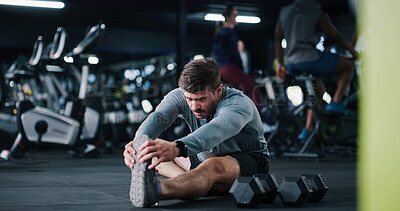 Buy stock photo Man, stretching or leg with workout preparation for exercise or indoor training on gym floor. Active, male person or getting ready with warm up or dumbbells for flexibility or fitness in health club