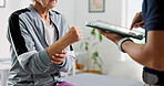 Physiotherapy, tablet and hands with old woman in clinic for wrist pain, rehabilitation and discussion. Online medical report, physical therapy progress and advice with people for osteoarthritis