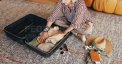 Buy stock photo Mature woman, travel and packing with suitcase in home for holiday, vacation or getaway. Hands, female person or traveler with clothing, luggage or passport ticket for preparation or flight booking