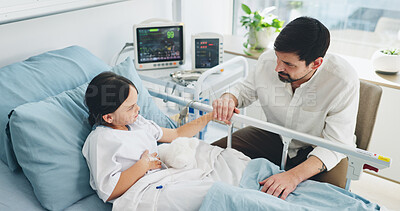 Buy stock photo Father, visit and holding hands with child in hospital bed for support, reassurance and medical recovery. Above, man or comfort kid for healing, family empathy and encouragement on healthcare surgery